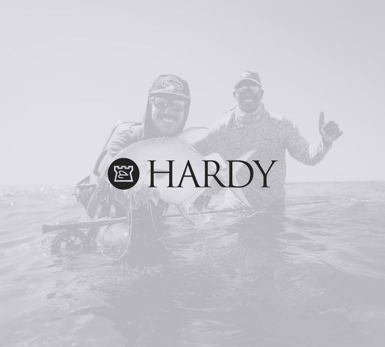Two people in waders with a Hardy logo overlay on a foggy background