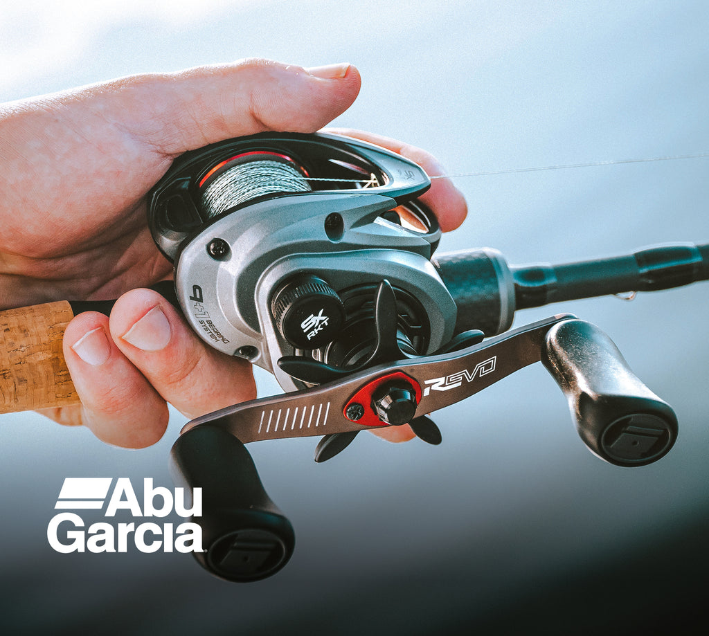 Fishing reel held in a hand with Abu Garcia branding