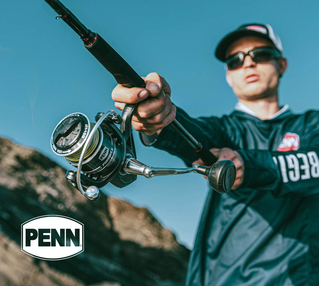 Person holding a fishing rod with a blue sky and mountain background, featuring the Penn logo.
